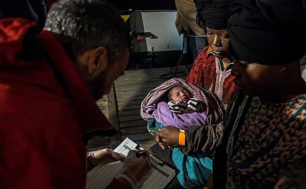 Un migrante rescatada con su bebé. 