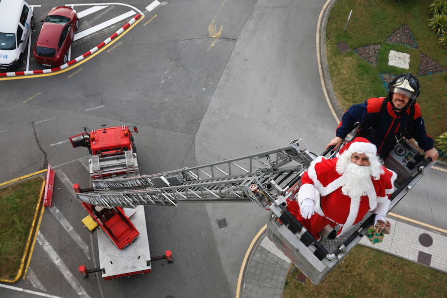 Los bomberos de Gijón escoltaron esta mañana a Papá Noel en una visita a los niños que están hospitalizados en el Hospital de Cabueñes.