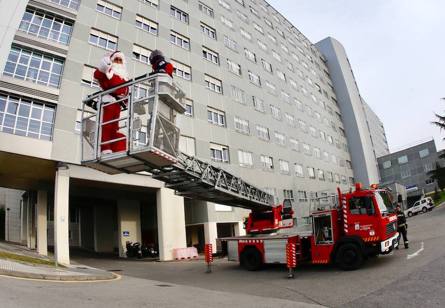 Los bomberos de Gijón escoltaron esta mañana a Papá Noel en una visita a los niños que están hospitalizados en el Hospital de Cabueñes.