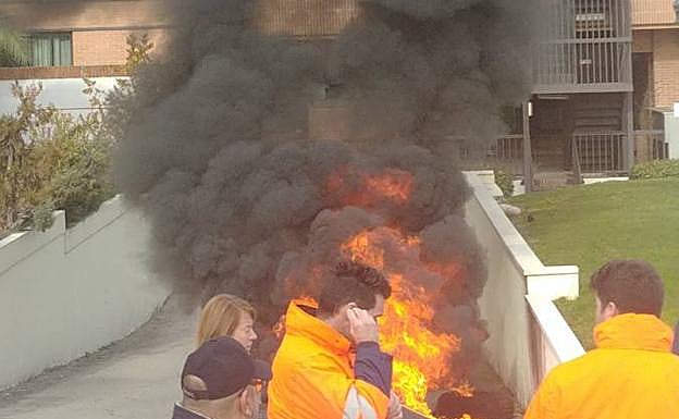 Los trabajadores gallegos de Alcoa queman neumáticos en los alrededores de donde se celebra la reunión 