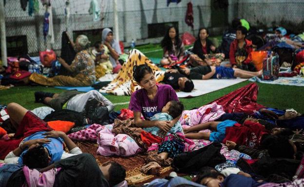 Desplazados por el tsunami descansan en un centro de evacuación en Labuan.