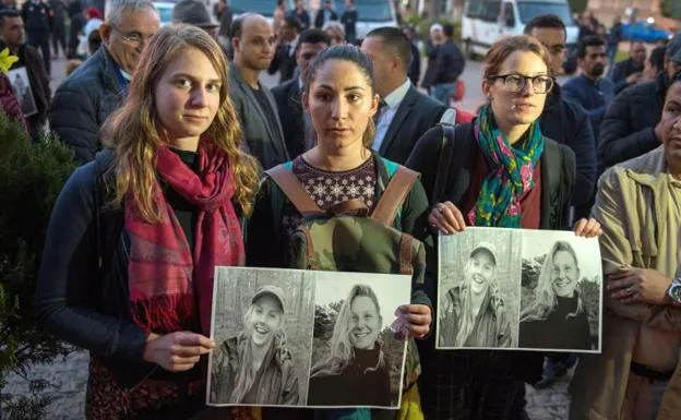 Turistas con fotos de las jóvenes asesinadas en un homenaje en Rabat. 