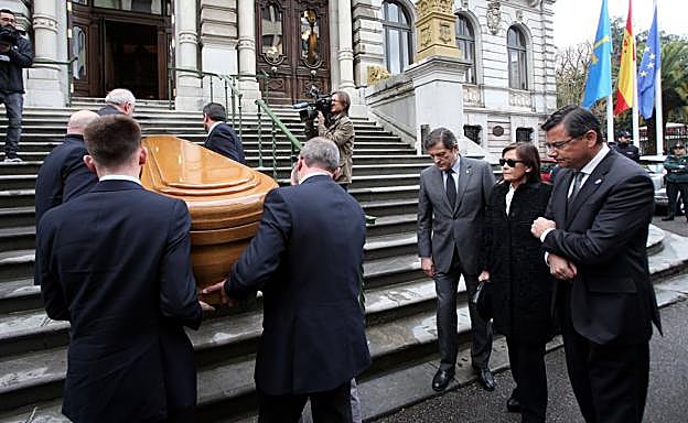 Imagen. Cinco hombres suben el féretro por las escaleras de la Junta ante la mirada de Javier Fernández, Soledad Saavedra y Pedro Sanjurjo. 