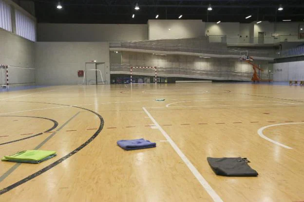 Varias toallas colocadas ayer en la pista del nuevo polideportivo de la Pola para empapar el agua de las goteras. 