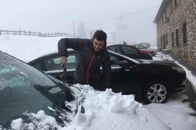 Pajares. Un joven, tratando de quitar la nieve de su coche