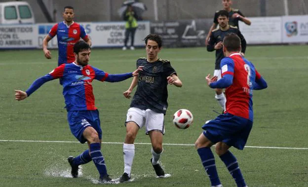 El azulgrana Héctor Nespral disputa el balón con el oviedista Marcelo, y con el langreano Cristian, a la derecha, atento a la jugada. 