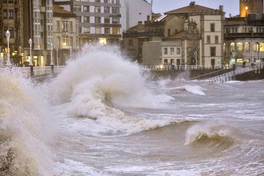 Un río Piles a punto de desbordarse, aguas turbias, o el oleaje rompiendo con fuerza en las escaleras del Muro son algunas de las imágenes que deja la pleamar esta tarde en Gijón
