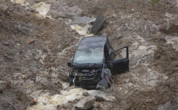 La Colladiella, en Mieres, con el coche siniestrado que conducía Miguel González, que se dirigía a esa zona a ver el estado de su ganado. :: D. ARIENZA