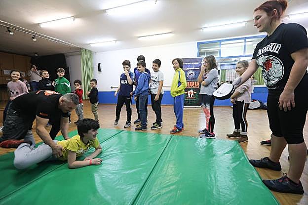 Javier Santos interactúa con uno de los asistentes al taller sobre la colchoneta. 