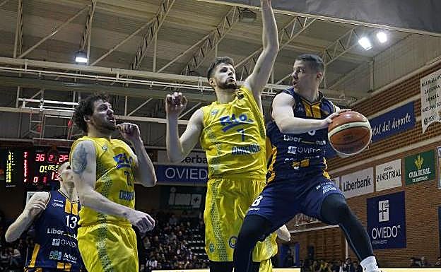 Ahonen trata de efectuar un pase bajo el aro ante la presión de Davis Rozitis. 