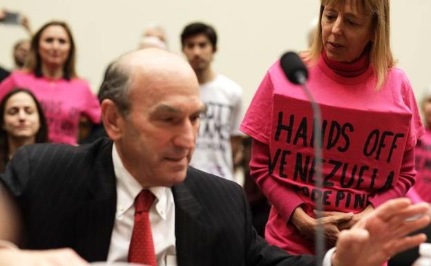 Elliott Abrams conversa con una activista. 