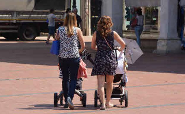 Dos madres paseando con sus bebés. 