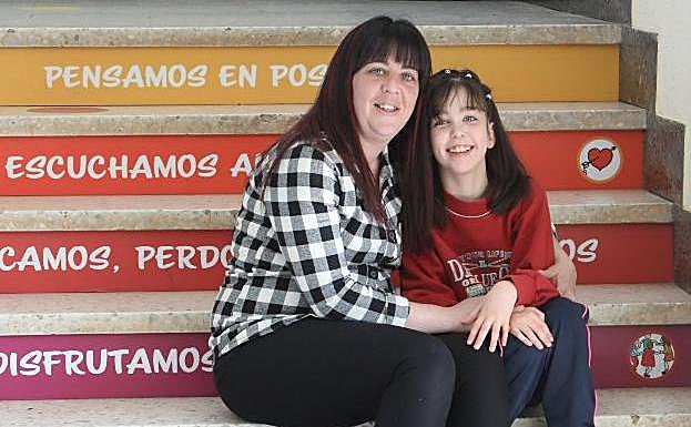 Mercedes, son su hija Alba, de doce años, en el colegio de educación especial al que asiste en Avilés. 