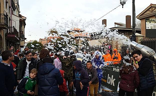 Adultos y niños disfrutan ya de los litros de agua y espuma del Descenso. 