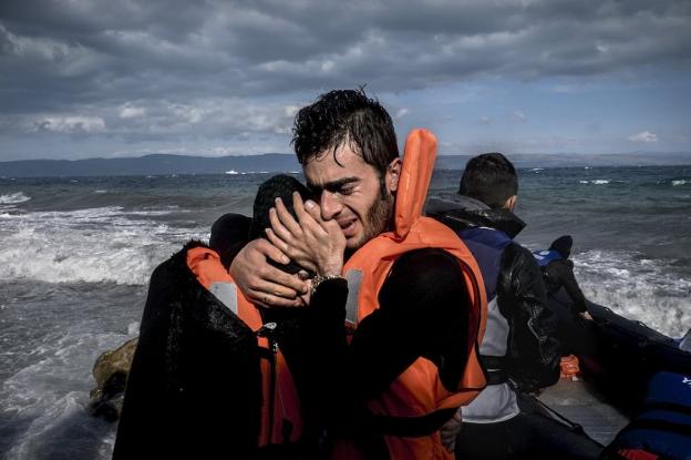 Los refugiados celebran su supervivencia al llegar a Lesbos, Grecia, 2015.