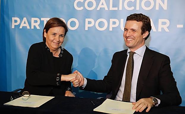 Pablo Casado y Carmen Moriyón se estrechan la mano en el acto de la firma del pacto entre los dos partidos
