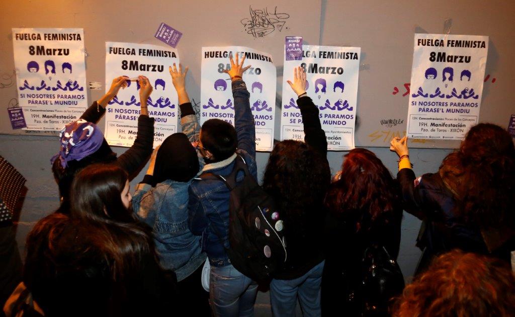 Un veintena de personas comenzó la jornada de huelga general feminista con una pega de carteles convocando a la manifestación de esta tarde en Gijón