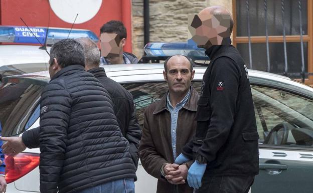 Efectivos de la Guardia Civil conducen a Javier Ledo a su vivienda, en el centro de Navia, para un registro.