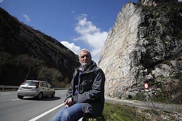 El alcalde de Caso, Miguel Ángel Fernández Iglesias, junto al talud que se vino abajo hace un año en Anzó. 