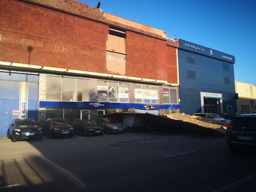 Parte de la estructura de la techumbre de una nave ha caído causando daños sobre siete vehículos. No hay heridos. La calle ha sido cortada para proceder a retirar el escombro