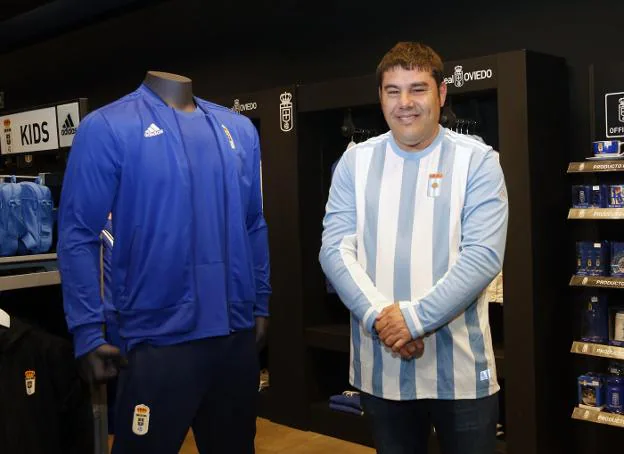 Un aficionado del Oviedo con la nueva camiseta del 93 aniversario. A la izquierda, una réplica del antiguo marcador. 