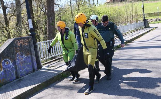 Efectivos de bomberos recuperan el cadáver de las aguas del Nora.