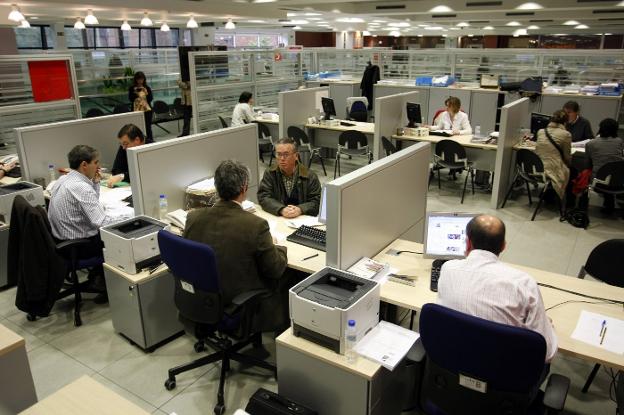 Funcionarios atienden a varios contribuyentes en una oficina de la Agencia Tributaria. 