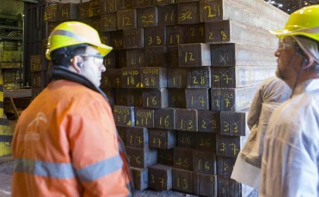 Un trabajador de Arcelor muestra las instalaciones del tren de carril de la planta de Gijón a una visita. 