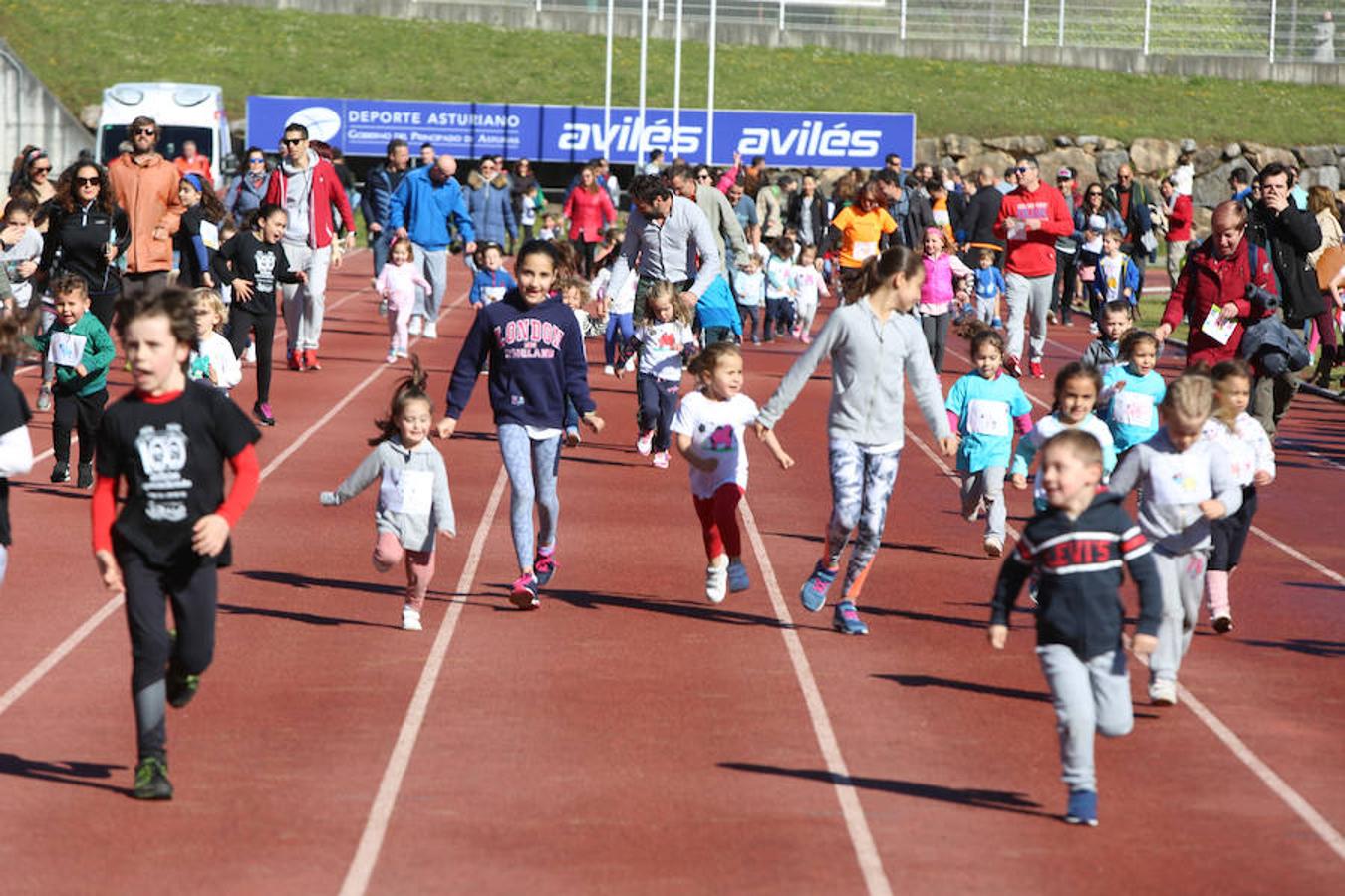 Cientos de escolares avilesinos y castrillonenses participan en la carrera solidaria celebrada en el estadio de atletismo Yago Lamela