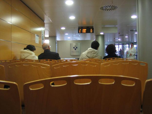 Los pacientes esperan a que su número salga en pantalla para entrar en consulta en el San Agustín. . 