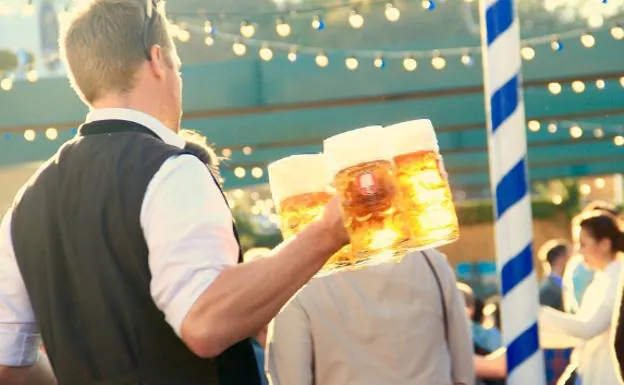 Un camarero lleva unas cervezas en Múnich. 