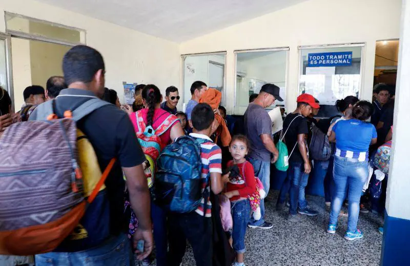 Los migrantes centroamericanos que se dirigen a Estados Unidos caminan en caravana a lo largo de la carretera entre Metapa y Tapachula en México