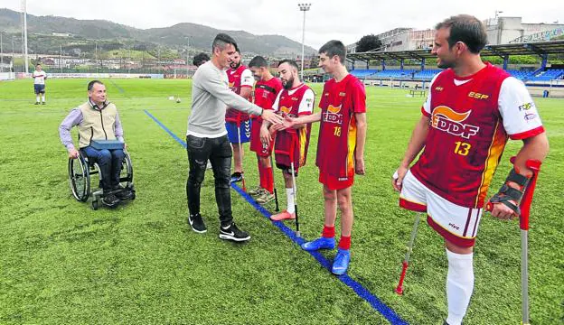 El futbolista del Real Oviedo Saúl Berjón saluda a los integrantes de la selección española de amputados. 