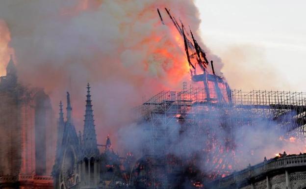 La aguja central de la catedral de Notre Dame cae durante el incendio este lunes en París.