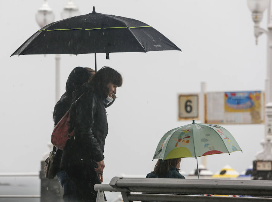 Aunque la mañana había librado del agua, las lluvias hicieron su aparición en Gijón por la tarde, con intensidad y acompañadas de tormenta