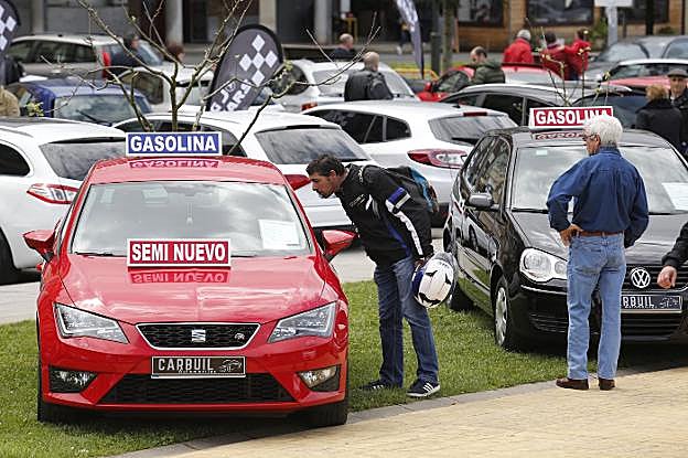 Un joven observa el interior de un vehículo en la Feria del Motor de Villaviciosa. 
