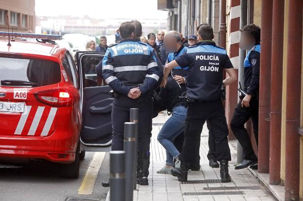 Momento en el que una de las implicadas es introducida en el coche patrulla.