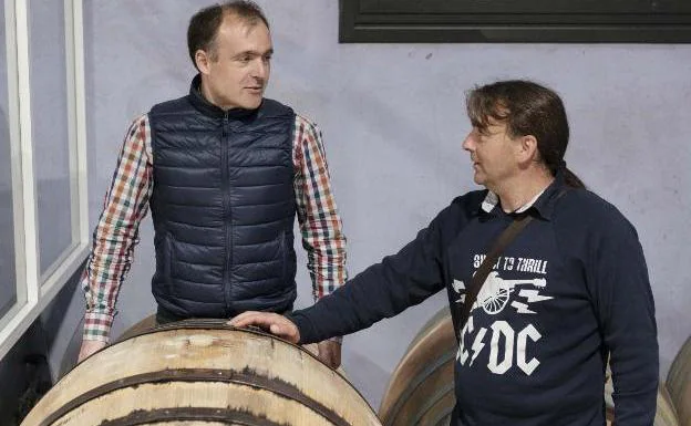 José y Carlos Argüelles, frente a un tonel hecho por ellos a partir de madera de castaño asturiano.