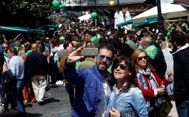 Una pareja se hace un 'selfi' en la calle Gascona de Oviedo llena de participantes en la Preba de la sidra. 