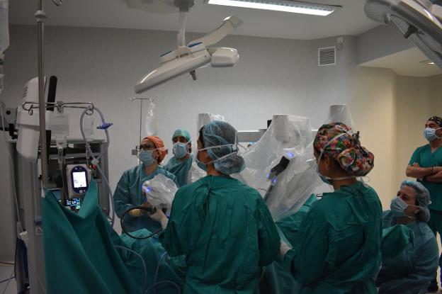 La doctora Lucía Vior, primera por la izquierda, ajusta la posición del robot Da Vinci antes de iniciar la intervención. :: MARÍA GUTIÉRREZ