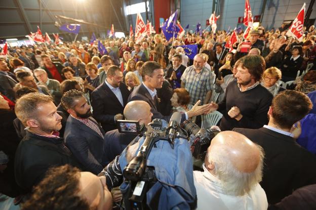 El presidente del Gobierno, Pedro Sánchez, saluda a uno de los asistentes al mitin celebrado ayer en Gijón, seguido del candidato autonómico, Adrián Barbón. 