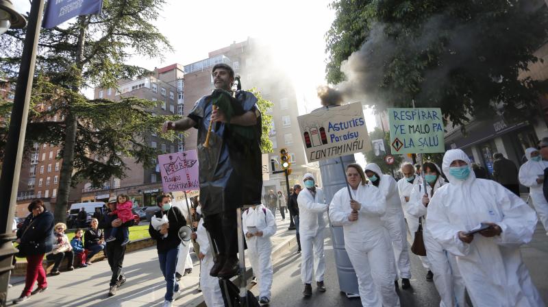 Un centenar de militantes y simpatizantes de Podemos-Equo han protagonizado un pasacalles contra la contaminación en la zona oeste de Gijón. Los participantes, ataviados con trajes de aislamiento y mascarillas, han llamado la atención de los viandantes con una puesta en escena teatral y portando una gran chimenea que no paraba de humear. Yolanda Huergo, Daniel Ripa y Lorena Gil estuvieron entre los participantes en esta 'performance'. 