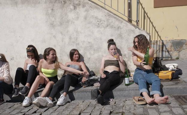 Unas jóvenes disfrutan de una jornada soleada en la 'Cuesta del Cholo', en Gijón. 