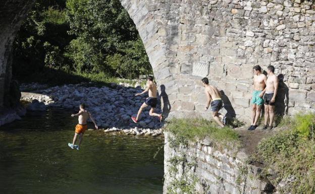 Unos jóvenes se bañan en Puente d' Arcu, en Laviana.