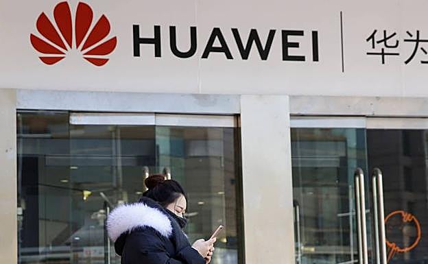 Una mujer pasa por delante de una tienda Huawei en China.