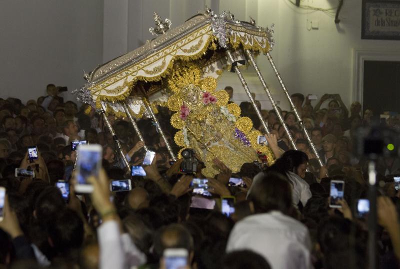 Multitudinaria y larga procesión de la Virgen del Rocío en Almonte (Huelva). En torno a las 2.49 horas de este Lunes de Pentecostés tuvo lugar el 'salto de la reja' y la imagen salió de la ermita para comenzar la tradicional procesión a hombros de los almonteños que se ha prolongado hasta las 12.31 horas, cuando ha vuelto a su Santuario. En su recorrido ante las 124 hermandades participantes, la Virgen ha vestido traje y manto con más de 2.000 piezas bordadas en oro fino en el taller de Fernando Calderón.