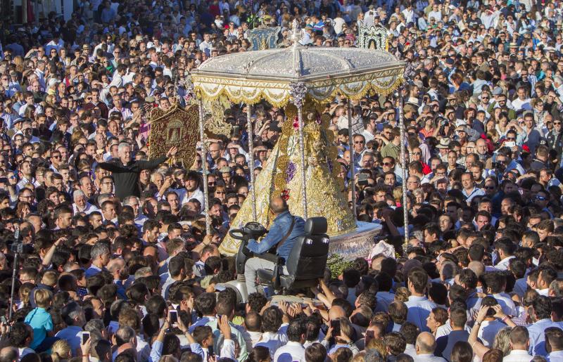 Multitudinaria y larga procesión de la Virgen del Rocío en Almonte (Huelva). En torno a las 2.49 horas de este Lunes de Pentecostés tuvo lugar el 'salto de la reja' y la imagen salió de la ermita para comenzar la tradicional procesión a hombros de los almonteños que se ha prolongado hasta las 12.31 horas, cuando ha vuelto a su Santuario. En su recorrido ante las 124 hermandades participantes, la Virgen ha vestido traje y manto con más de 2.000 piezas bordadas en oro fino en el taller de Fernando Calderón.