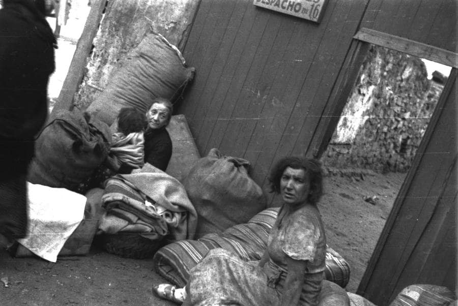 Mujeres en la calle con enseres rescatados de sus casas, tras un bombardeo de la armada franquista, Gijón, 14 de octubre de 1937
