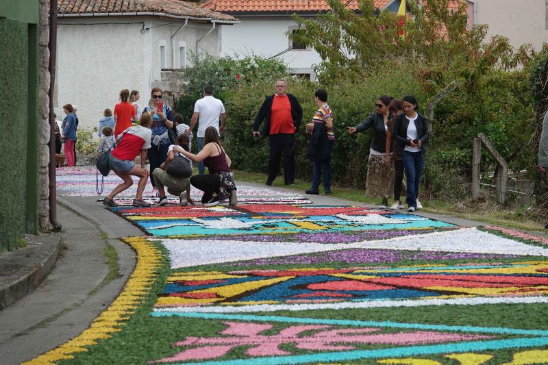 Las alfombras florales cubrieron las calles de la localidad llanisca de Cue, que ha celebrado la fiesta de la Sacramental. El disparo de 5.400 voladores puso el broche a la celebración.