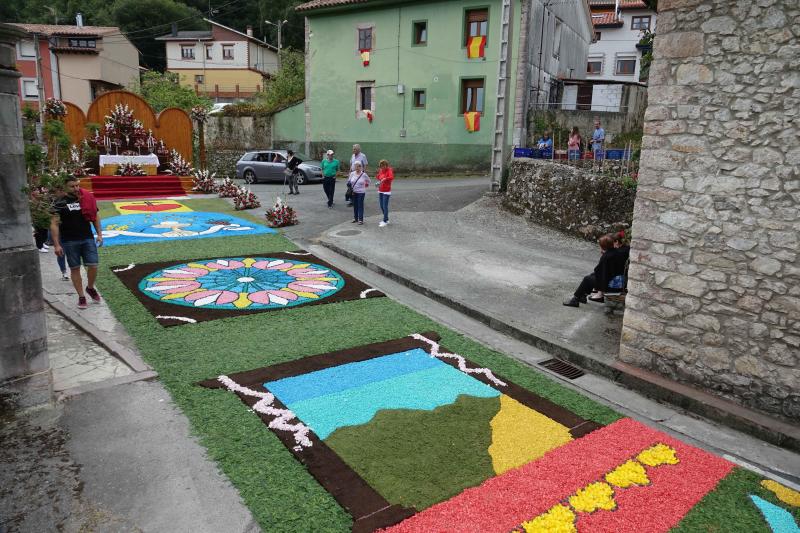 Las alfombras florales cubrieron las calles de la localidad llanisca de Cue, que ha celebrado la fiesta de la Sacramental. El disparo de 5.400 voladores puso el broche a la celebración.